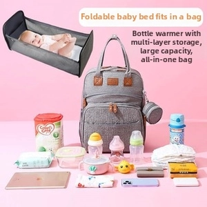 Detail view of foldable diaper bag expanding into a travel bassinet with thermal bottle pockets