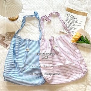 Detailed view of casual striped canvas tote bags in light blue and lavender colors