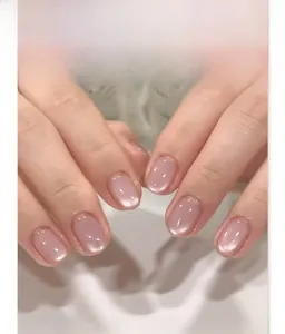 Close-up of nude pink cat-eye press-on nails with shiny jelly texture finish
