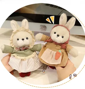 Dettaglio di simpatici coniglietti di peluche con vestito di pizzo e carota