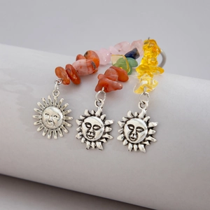 Detail of silver sun face earrings with red agate, rose quartz, and citrine beads