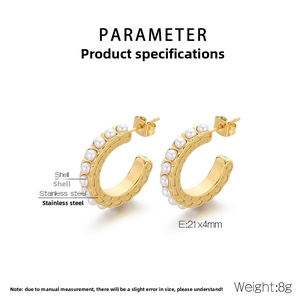 Detail of vintage C-shaped stainless steel earrings with inlaid white pearls