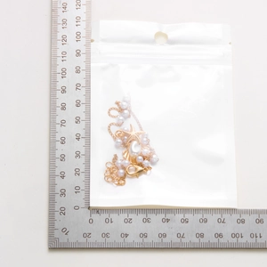 Detail view of starfish pearl necklace in packaging with size measurement ruler