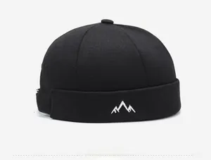 Detail view of black vintage docker hat with mountain peak embroidery on the brim