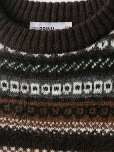 Detail of soft jacquard knit sweater showing crew neck ribbing and woven neck label