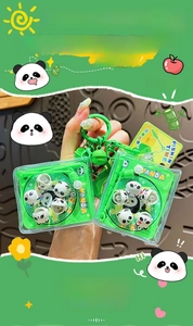 Detail of cute panda fishing game keychain with green transparent box and bell attachment