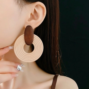 Boucles d'oreilles bohèmes en bois géométriques avec clou ovale sur un mannequin