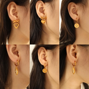 Set of six gold plated bow and heart earrings featuring irregular designs on models