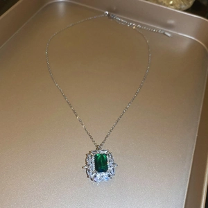 Dettaglio macro del ciondolo smeraldo rettangolo con bordo in zircone su catena argento