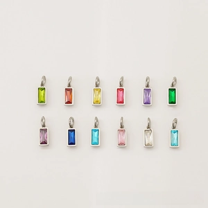 Vue macro de douze pendentifs rectangulaires en zircone colorée avec bords en acier