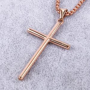 Macro shot of a rose gold stainless steel cross pendant on a square box chain