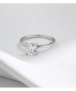 Macro close-up of a pear-shaped moissanite ring set in s925 silver on soft white fabric