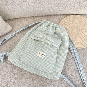 Detailed view of quilted gingham backpack with drawstring closure and front zip pocket
