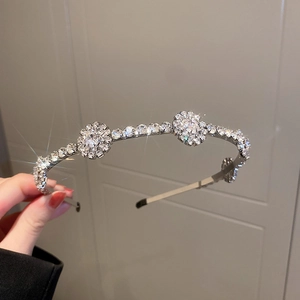 Dettaglio ravvicinato di un cerchietto argento con foglie di cristallo e strass brillanti