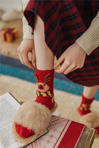 Detail of soft red Christmas coral fleece socks with 3D reindeer embroidery and slippers