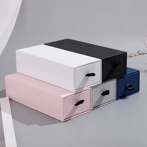 Stack of textured drawer gift boxes in five colors with elegant ribbon pull handles