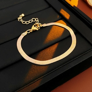 Detail of gold snake chain bracelet with extension and lobster clasp in black jewelry box