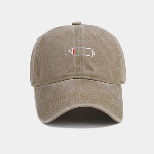 Macro detail of Khaki low battery 1% embroidery on vintage washed cotton baseball cap