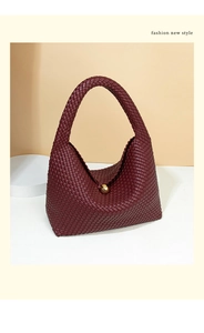 Detail of burgundy woven hobo bag showing intricate texture and golden ball clasp