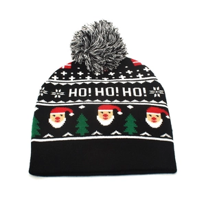 Detailed view of winter knit beanie featuring Santa Claus pattern and mixed fur pom-pom