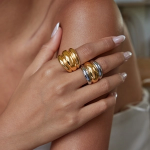 Close-up of model wearing two-tone gold and silver chunky ribbed stainless steel rings