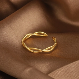 Detail of s925 gold intertwined ring with a double-line spiral design on silk background