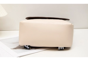 Detailed base view of cream backpack showing smooth PU leather and geometric straps