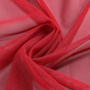 Macro shot of sheer red mesh fabric showing fine texture on a slim evening gown