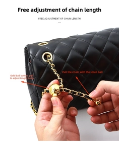Detail of adjustable gold ball buckle on black quilted leather bag chain strap