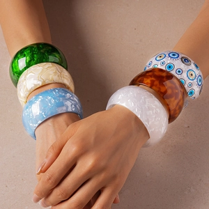 Detailed close-up of colorful acrylic geometric bangles featuring marble patterns and evil eye motif