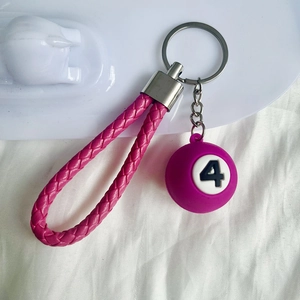 Detail of pink braided leather strap with purple number 4 billiard ball pendant keychain