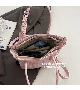 Top view of pink woven bucket bag showing spacious interior with zipper pockets