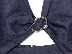 Detail of a dark blue denim midi dress with a silver irregular metal ring and zipper closure