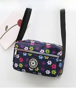 Detail of floral nylon crossbody bag with adjustable strap and circular SPORT logo