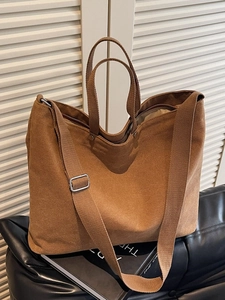 Minimalist brown canvas tote bag with dual handles and long strap for daily commute