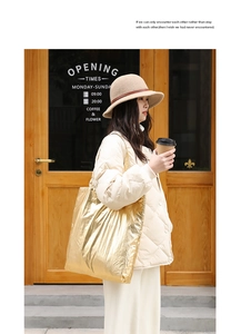 Fashionable gold metallic tote bag styled with a winter outfit in a cozy street setting