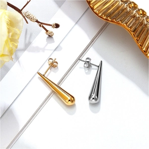 Macro shot of polished waterdrop stud earrings in gold and silver finish with ear backs