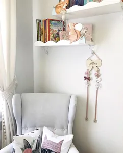 Detail view of wooden bow hair clip holder with pink ribbons for kids room storage