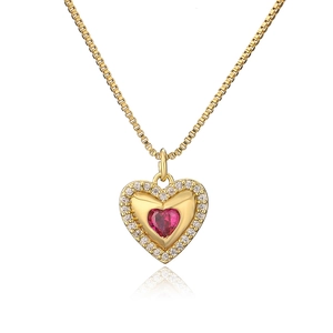 Detail of 18K gold heart necklace featuring a red zircon center and halo stones