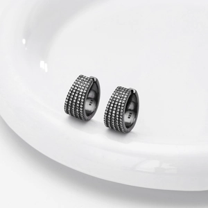 Macro shot of 925 sterling silver huggie earrings with micro-pave cubic zirconia on ceramic