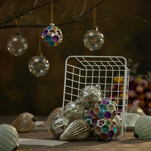 Assorted Christmas glass ornaments in metal basket with glitter and faceted designs