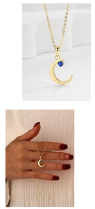 Detail view showing a golden crescent moon necklace with a blue stone inlay on a thin chain