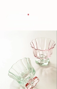 Détail de coupes à dessert en verre à bord de pétales rose et vert avec motifs ondulés