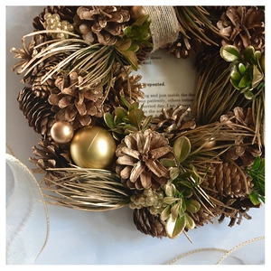 Macro detail of pine cone textures and golden ornaments on a festive Christmas wreath