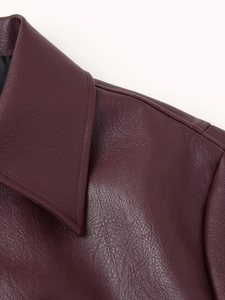 Detail view of the lapel and shoulder on a burgundy vintage faux leather jacket