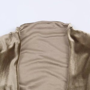 Detail of champagne gold velvet fabric with elegant shoulder pleats and soft texture