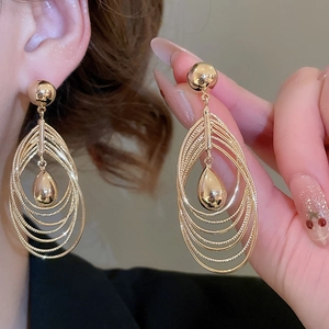 Macro detail of 18k gold plated multi-layer teardrop earrings with a polished finish