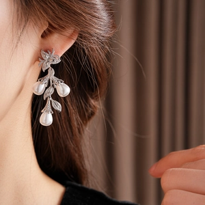 Détail de boucles d'oreilles feuilles en argent avec zircons et perles en forme de goutte