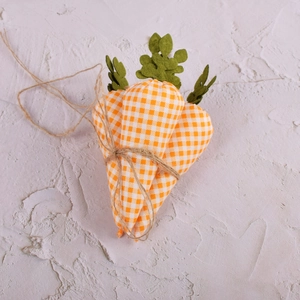 Close-up of fabric Easter carrot ornaments with orange plaid patterns and jute rope