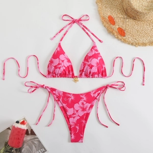 Detail of rose pink hibiscus print bikini with a gold floral metal connector